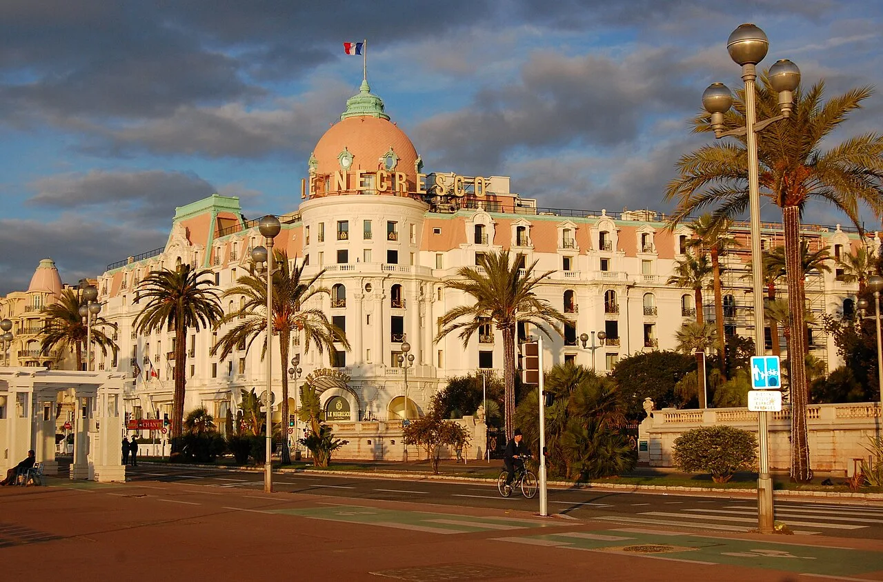 Façade du Negresco et coupole rose sous un ciel nuageux